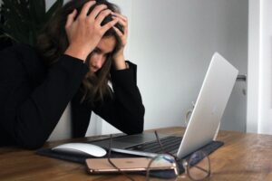 Frau, die beim Hausverkauf verzweifelt auf ihren Laptop schaut