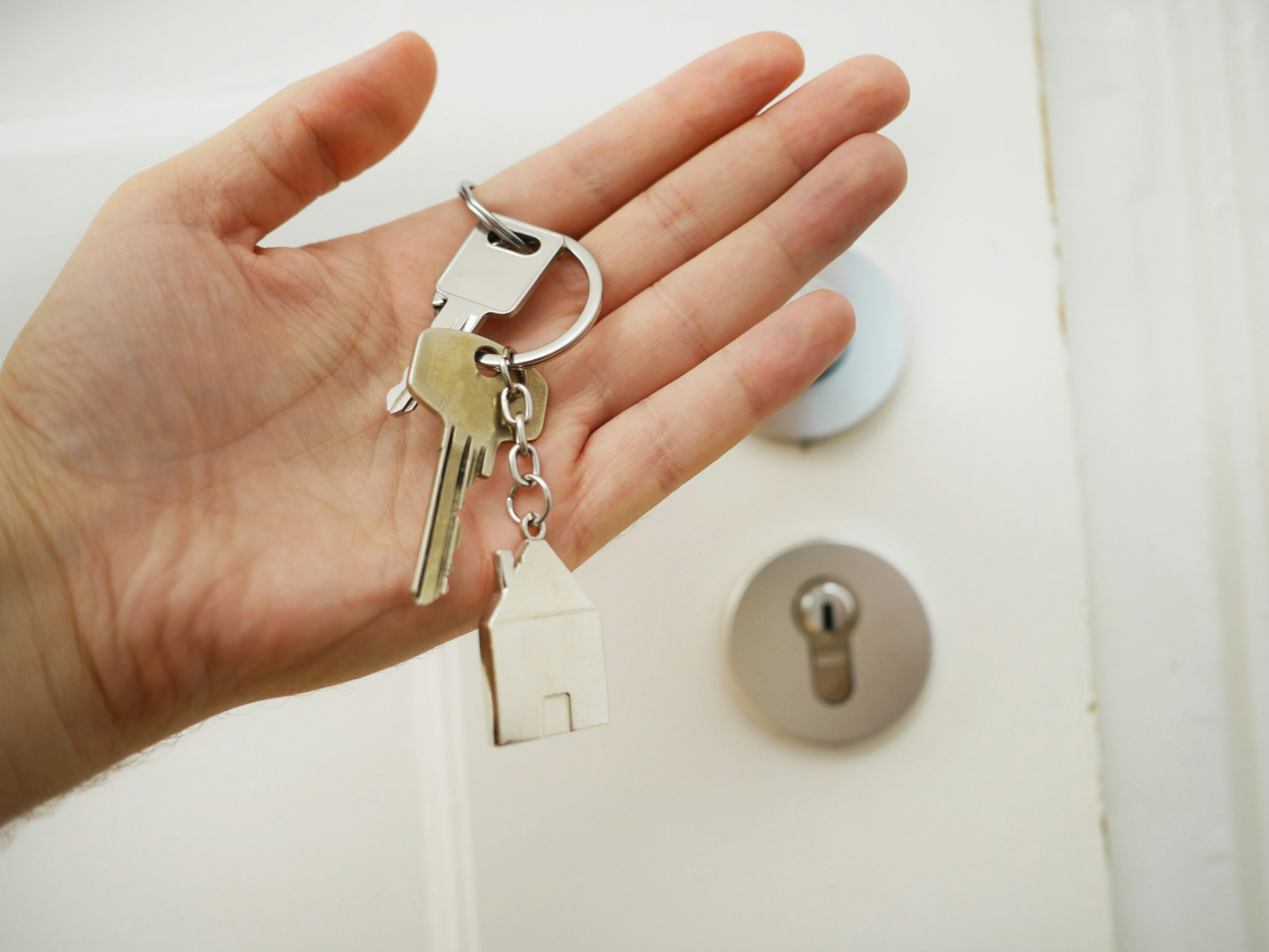Schlüsselbund mit Hausanhänger vor Wohnungstür bei einer Wohnungsübergabe